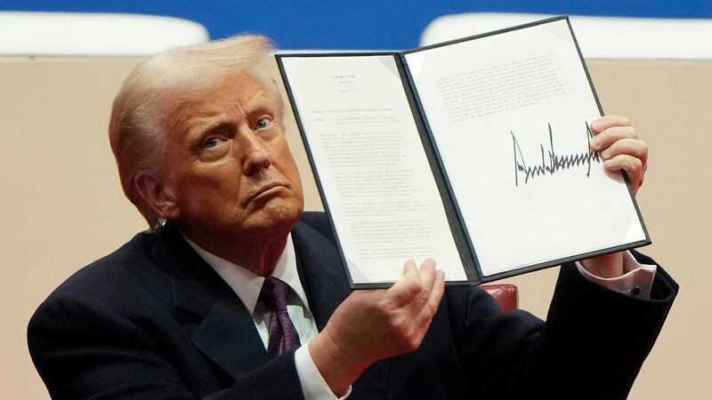 Donald Trump firmando una orden ejecutiva.